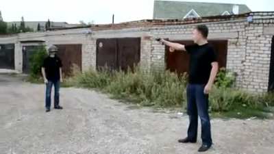 Man tests if a helmet is bulletproof with a gun.