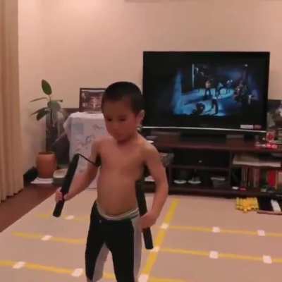 A child imitating Bruce Lee perfectly.