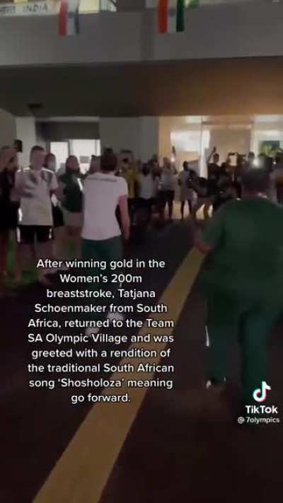 After winning gold in the women’s 200m breaststroke, Tatjana Schoenmaker from South Africa, returned to the team Olympic Village and was greeted with a rendition of the traditional South African song ‘Shosholaza’ meaning ‘go forward.’