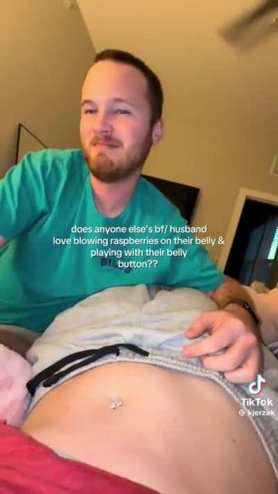 Boyfriend blows raspberries on girlfriend belly button