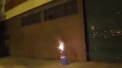 Alguem acende fogo de artificio que explode em prédio