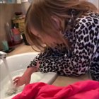 Girl gags when mom pretends to put poo on her hand.