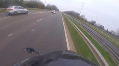 Idiot driver almost hits a biker while entering a dual carriageway.