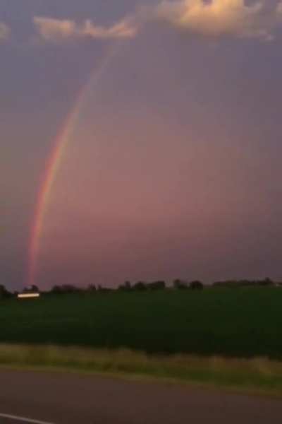 Rainbow with lightning striking past it. Very mesmerising.
