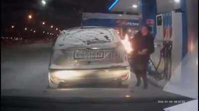 Using a lighter to see the gas pump nozzle