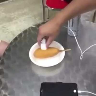 Charging a phone with Monster Energy and a corn dog