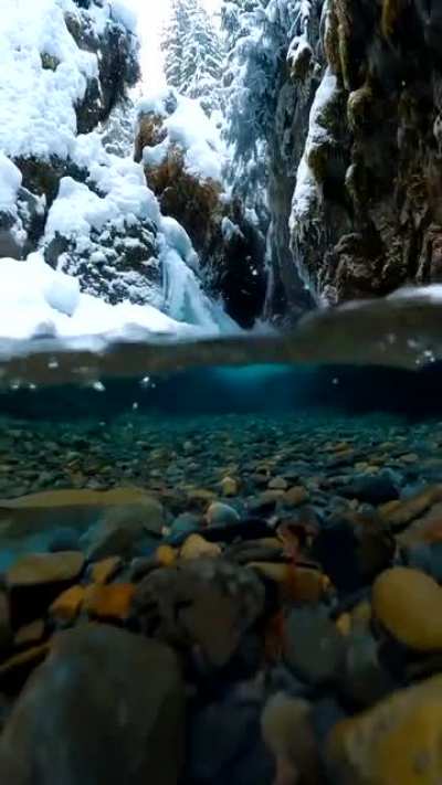 Snow falling on crystal clear Alaskan glacial melt water. Credit: Photographer John Derting.
