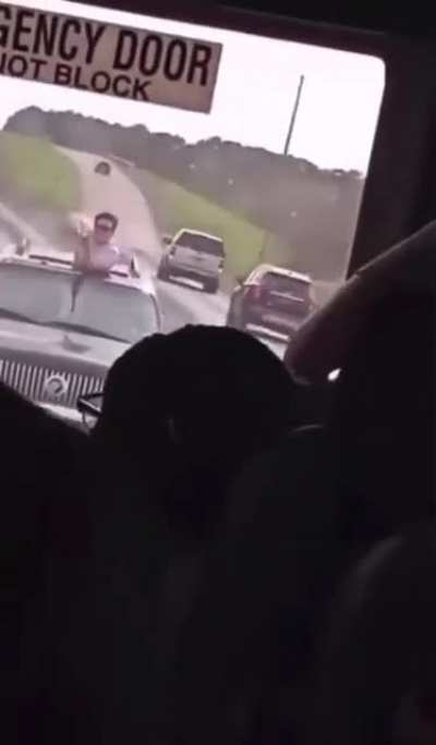 Someone in Texas pokes out of a sunroof and points a firearm at a bus full of kids