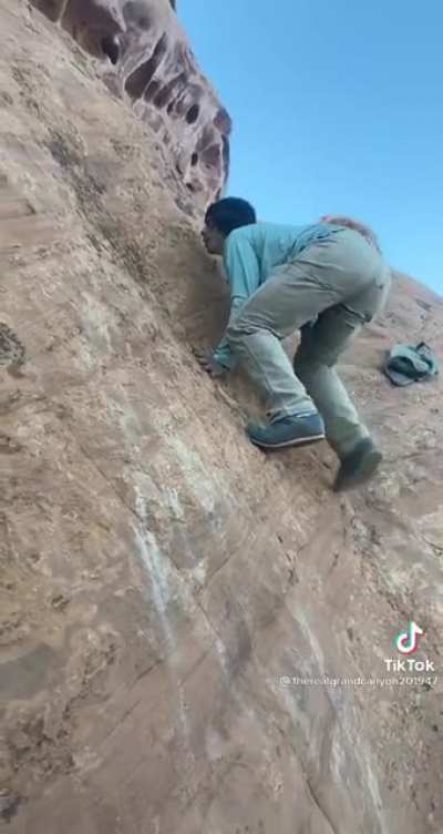 Gravity and friction team up to stop this idiot from climbing up a rock