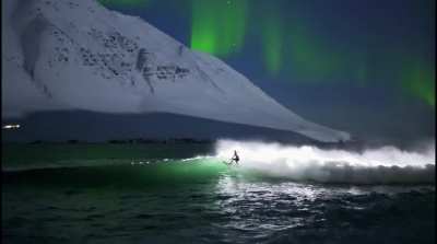 Cold water surfing under the Northern Lights in Iceland, shot by Chris Burkard.