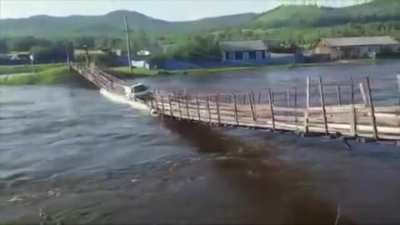 Rickety suspension bridge in Russia collapses into flooded river as delivery truck drives over it (July 23)