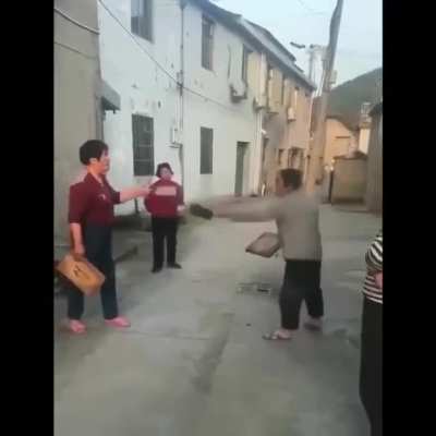 Two women arguing (ovet the quality of their cutting board?), somewhere rural in China