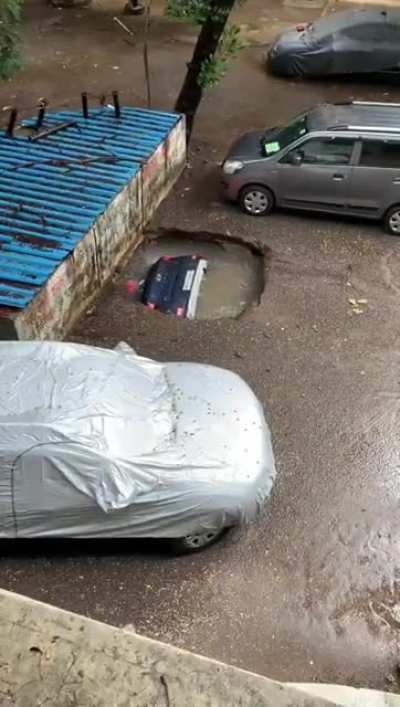 a car sinking in a sinkhole in Mumbai's Ghatkopar