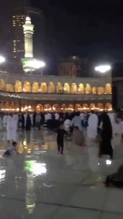 Children enjoying the rain in the Al-Haram Courtyard