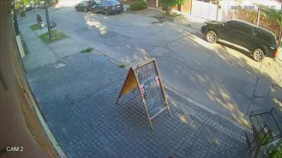 Una mujer lanza un cascote al vidrio de un edificio
