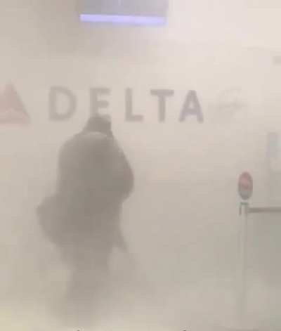 Woman spraying fire extinguisher at employees