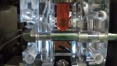 Strech Blow Molding a PET preform into a bottle using a transparent mold.