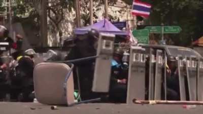 Thai police officer tries to kick a grenade that was thrown at them.
