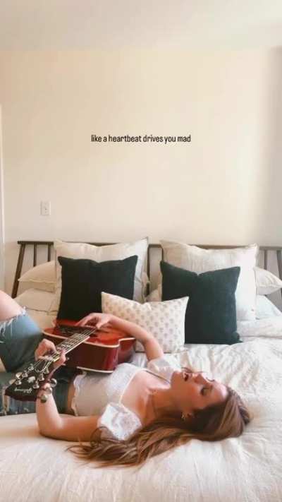 Playing a song on her guitar on the dreamiest bed of all time (May 2023)