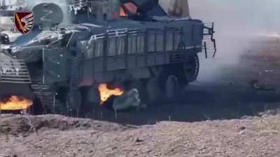 A crew member of a Russian BMP-3 tries to crawl out from under a burning vehicle. Donetsk region
