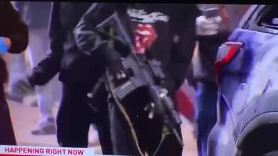 Rioter pulls AR-15 from cop car, gets stopped immediately by private security officer for news team