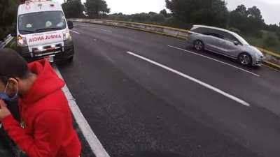 Bikers and paramedics checking on bike crash victims almost get hit by uncontrolled SUV.
