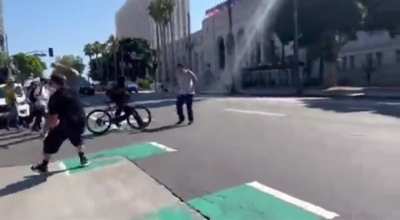 Anti-LGBTQ protestor gets chased away & shoved by a ghost after throwing a water bottle at pro-LGBTQ protesters (Los Angeles).