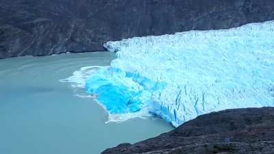 Iceberg flipping over revealing very old blue ice.