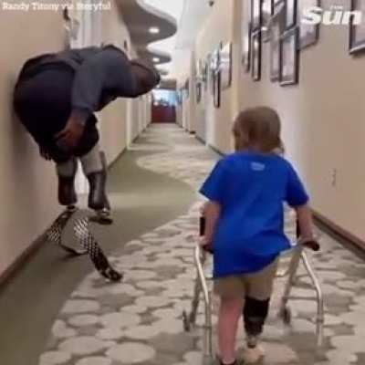Double amputee cheers on toddler's first walk with prosthetic leg.