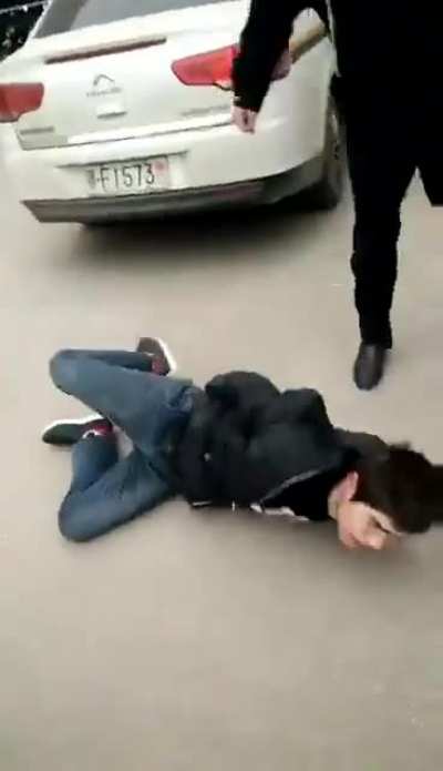 Police in China beating up a man until he spits out blood