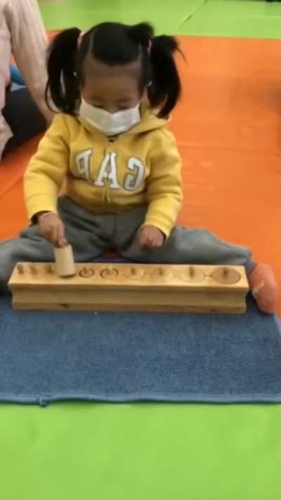 Kid plays with cylinder game