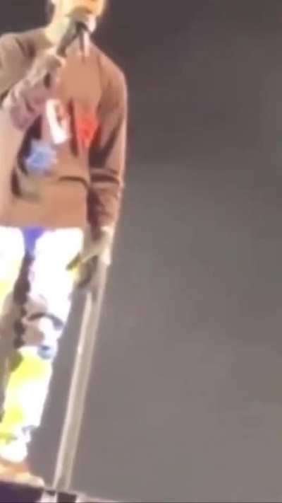 Travis Scott looks on + continues to sing as he watches a fans lifeless body carried away