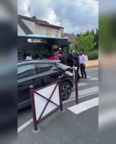 Teens manage to move a car which was blocking the street to a stuck bus in Paris